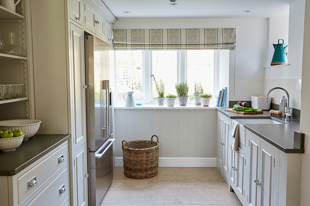 Immagine di una cucina parallela tradizionale di medie dimensioni con lavello stile country, ante in stile shaker e ante bianche