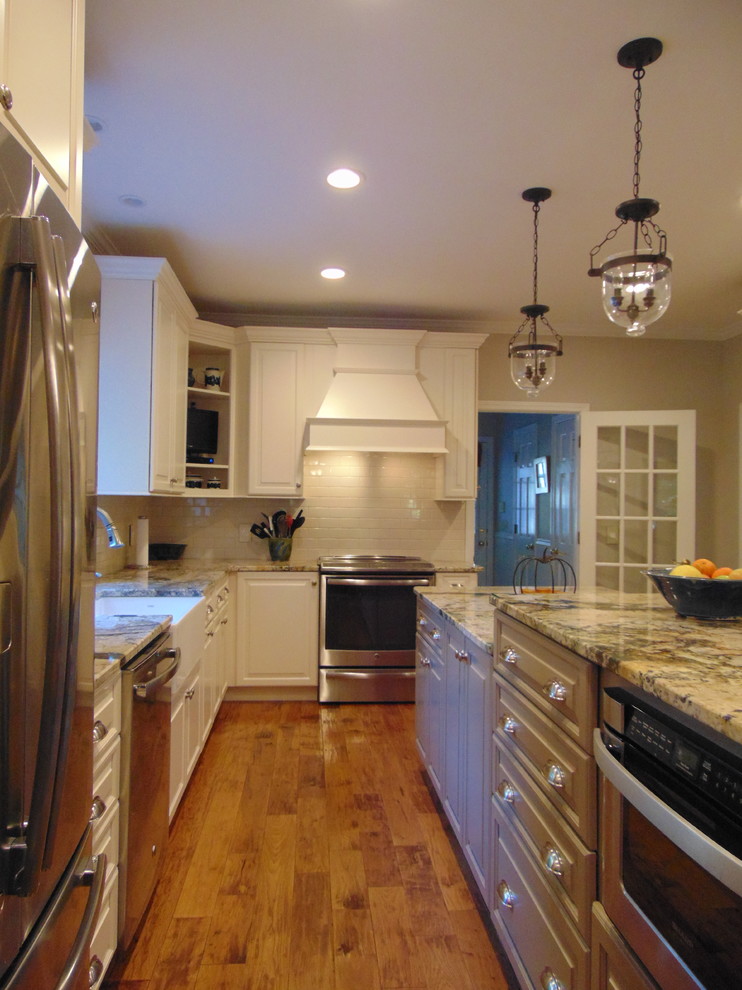 Bild på ett mellanstort vintage kök, med en rustik diskho, luckor med upphöjd panel, vita skåp, marmorbänkskiva, vitt stänkskydd, stänkskydd i tunnelbanekakel, rostfria vitvaror, mellanmörkt trägolv och en köksö