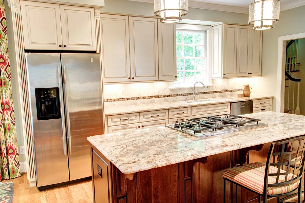 This is an example of a traditional kitchen in Raleigh with granite worktops, stainless steel appliances and medium hardwood flooring.