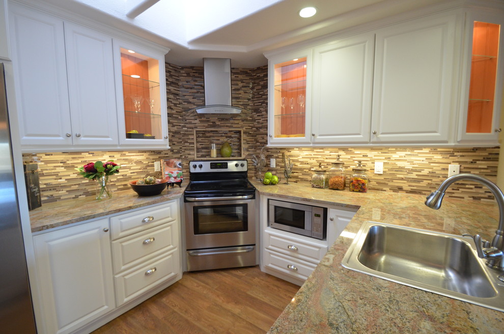 Example of a classic u-shaped medium tone wood floor eat-in kitchen design in San Francisco with raised-panel cabinets, white cabinets, multicolored backsplash, stainless steel appliances and a peninsula