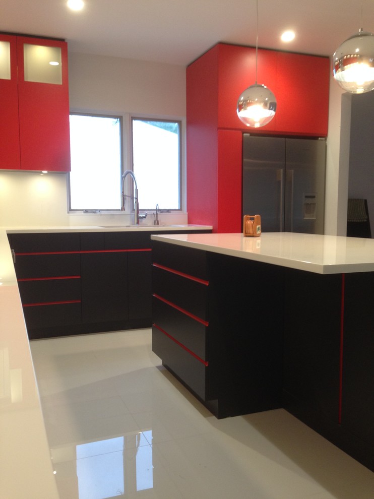 Eat-in kitchen - mid-sized modern l-shaped eat-in kitchen idea in New York with a double-bowl sink, flat-panel cabinets, red cabinets, glass countertops, white backsplash, glass sheet backsplash, stainless steel appliances and an island