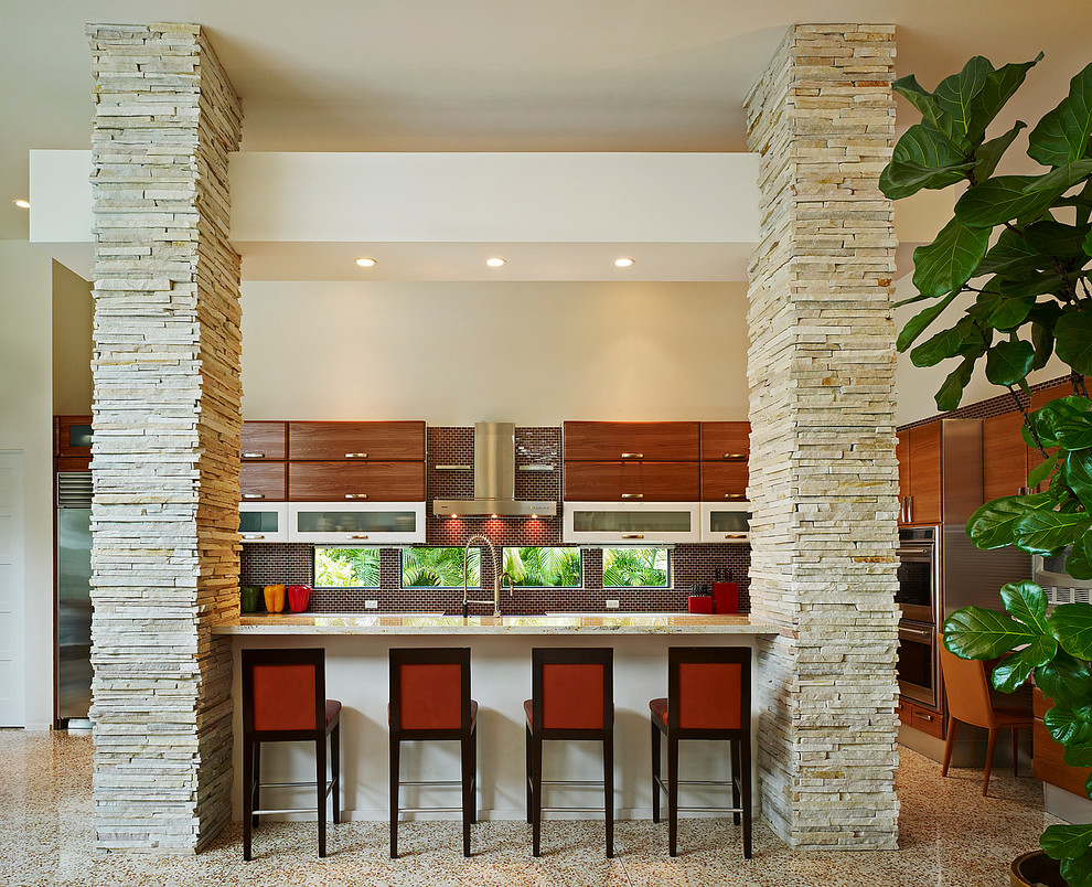 На фото: угловая кухня-гостиная в современном стиле с плоскими фасадами, темными деревянными фасадами, коричневым фартуком, фартуком из плитки мозаики и островом с