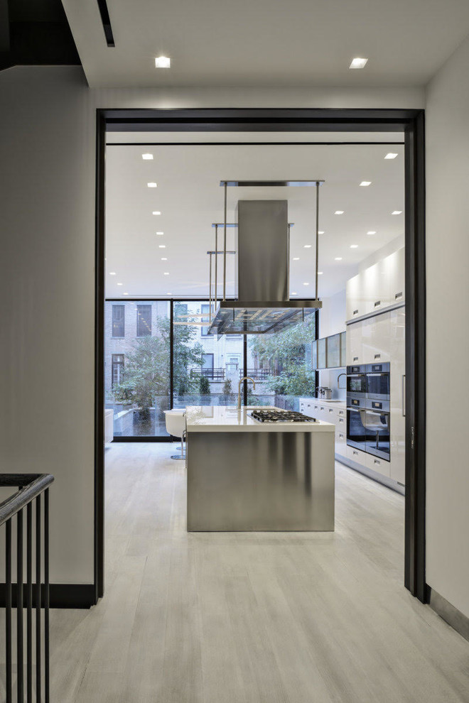 Moderne Wohnküche mit weißen Schränken, Glas-Arbeitsplatte und Kücheninsel in New York