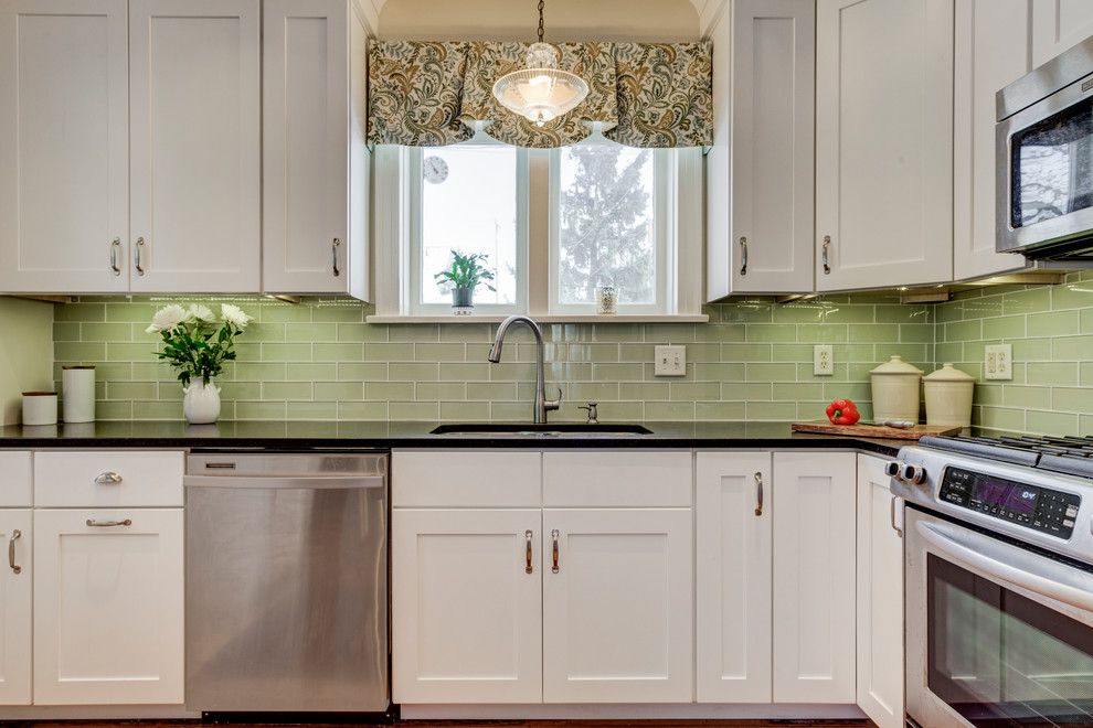 Inspiration for a mid-sized modern u-shaped light wood floor enclosed kitchen remodel in Los Angeles with an undermount sink, shaker cabinets, white cabinets, quartzite countertops, green backsplash, glass tile backsplash and stainless steel appliances