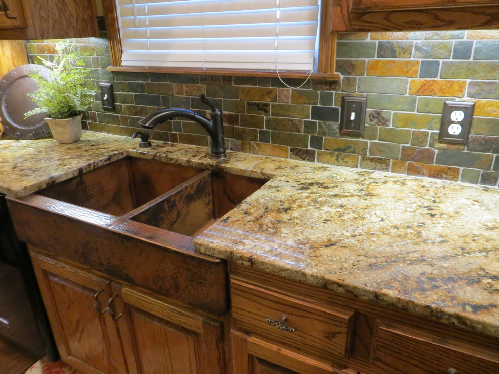 Inspiration for a rustic kitchen in Kansas City with a belfast sink, medium wood cabinets, granite worktops, multi-coloured splashback, stone tiled splashback and black appliances.