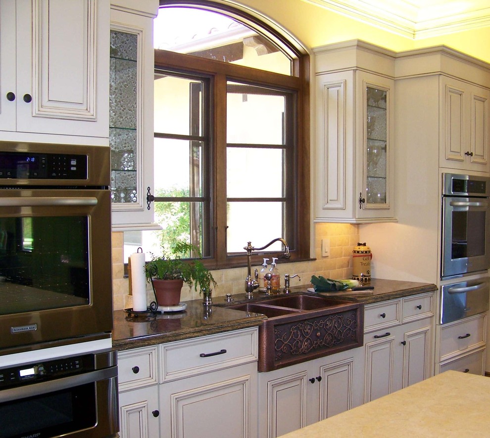 Bild på ett stort vintage kök, med rostfria vitvaror, en rustik diskho, marmorbänkskiva, vita skåp, beige stänkskydd, stänkskydd i stenkakel, luckor med upphöjd panel, klinkergolv i keramik, flera köksöar och beiget golv