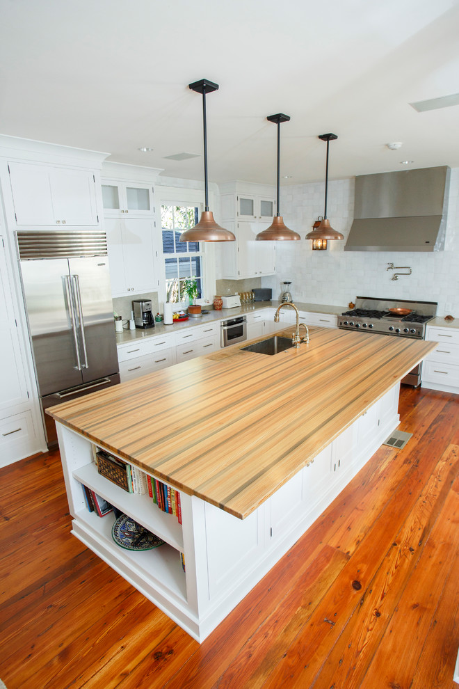 Foto på ett stort funkis flerfärgad kök och matrum, med en undermonterad diskho, luckor med profilerade fronter, vita skåp, träbänkskiva, rostfria vitvaror, mörkt trägolv, en köksö och brunt golv