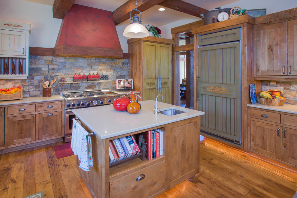 На фото: кухня в классическом стиле с фасадами цвета дерева среднего тона, фартуком из каменной плитки и техникой под мебельный фасад с