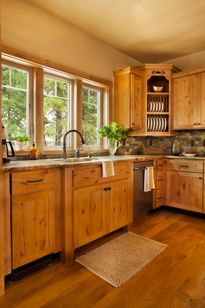 Photo of a rustic l-shaped kitchen/diner in Portland with shaker cabinets, medium wood cabinets, stainless steel appliances, medium hardwood flooring and an island.