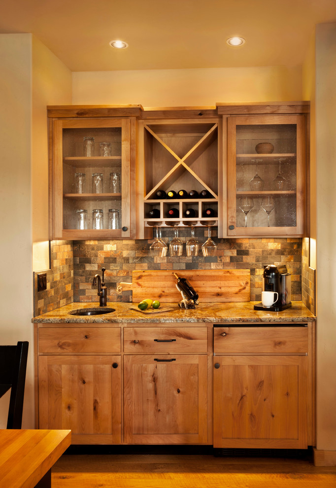 Diseño de cocina rústica con armarios estilo shaker, puertas de armario de madera oscura, electrodomésticos de acero inoxidable, suelo de madera en tonos medios y una isla