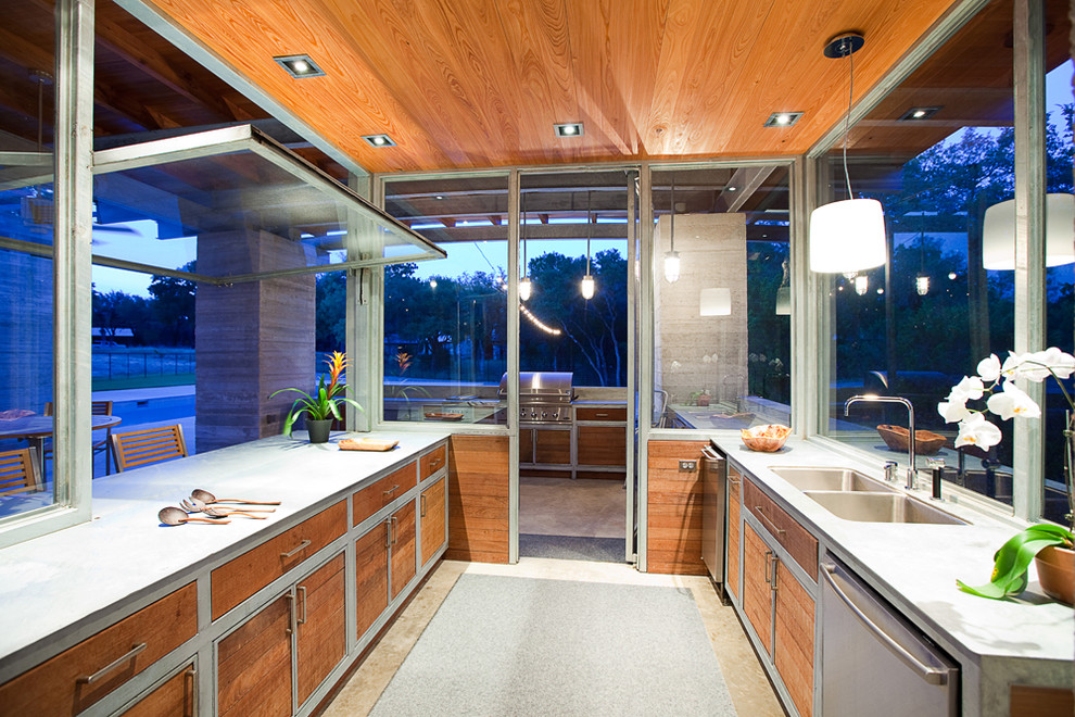 Photo of a medium sized contemporary galley open plan kitchen in Austin with a double-bowl sink, flat-panel cabinets, medium wood cabinets, concrete worktops, stainless steel appliances, concrete flooring and an island.