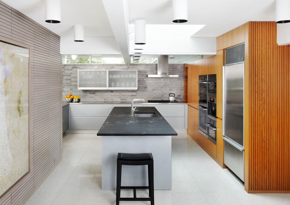 Midcentury kitchen in Minneapolis with soapstone worktops and a feature wall.