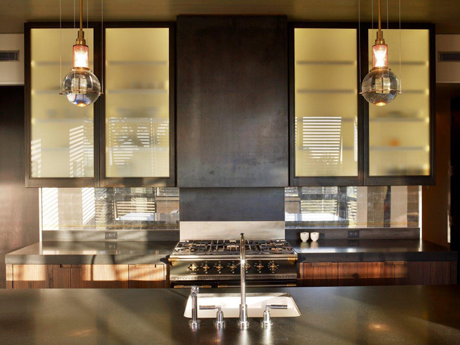 Esempio di una cucina parallela design con lavello sottopiano, ante lisce, ante in legno scuro, top in granito e elettrodomestici in acciaio inossidabile