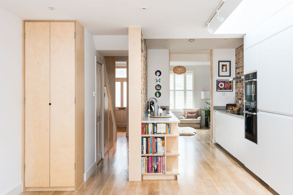 Foto di una cucina parallela scandinava di medie dimensioni con ante lisce, paraspruzzi in mattoni e pavimento beige
