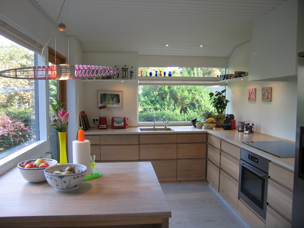 Foto di una cucina nordica con lavello sottopiano, ante lisce, ante in legno chiaro e nessuna isola