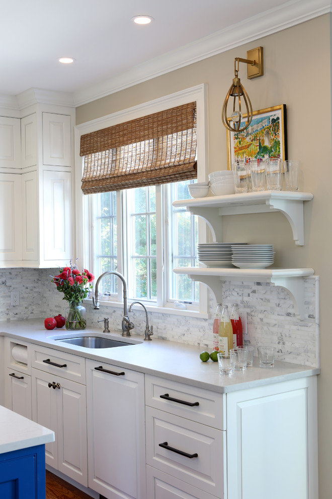 This is an example of a small traditional u-shaped kitchen/diner in New York with a submerged sink, beaded cabinets, white cabinets, engineered stone countertops, white splashback, marble splashback, stainless steel appliances, medium hardwood flooring, an island and beige floors.