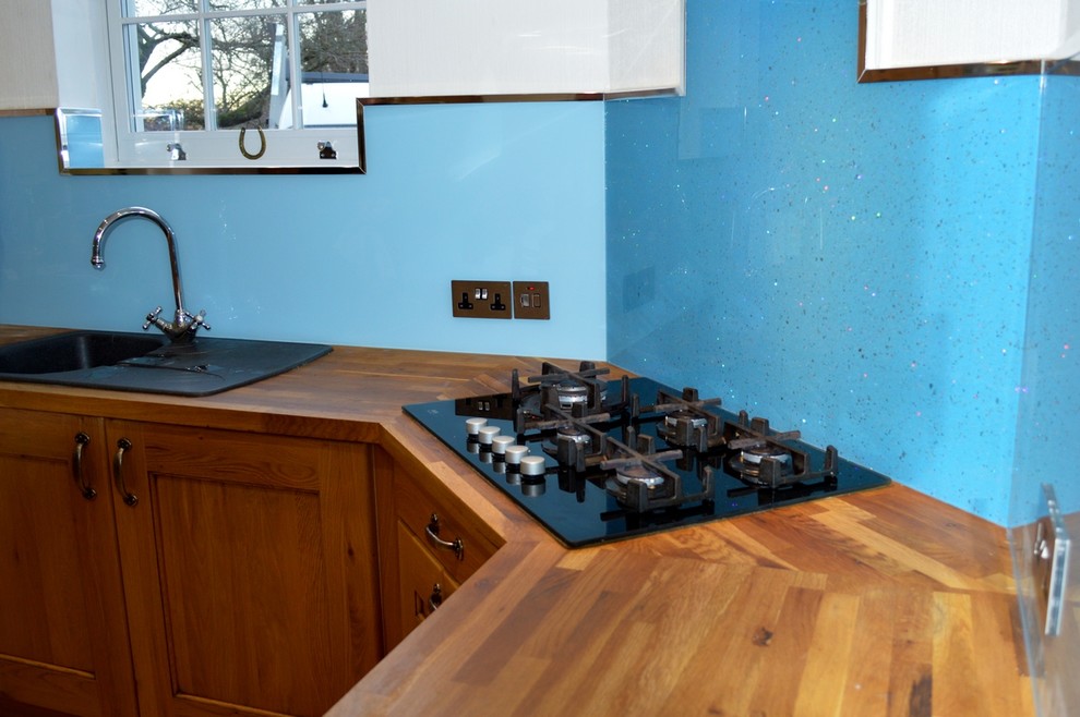 Contemporary kitchen in Hertfordshire with blue splashback and glass sheet splashback.