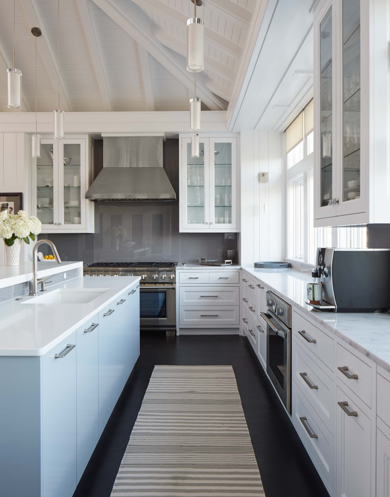 Coastal l-shaped kitchen in Other with a submerged sink, shaker cabinets, white cabinets, stainless steel appliances, dark hardwood flooring, an island, black floors and grey worktops.