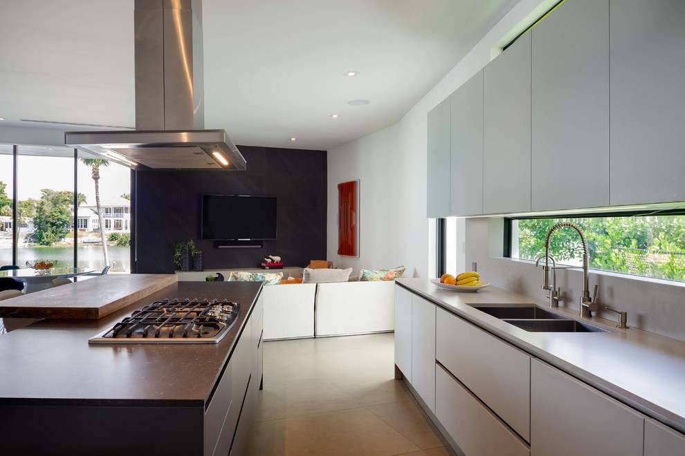 Mid-sized trendy u-shaped porcelain tile and gray floor eat-in kitchen photo in Miami with an undermount sink, flat-panel cabinets, gray cabinets, quartz countertops, gray backsplash, stainless steel appliances, an island and gray countertops
