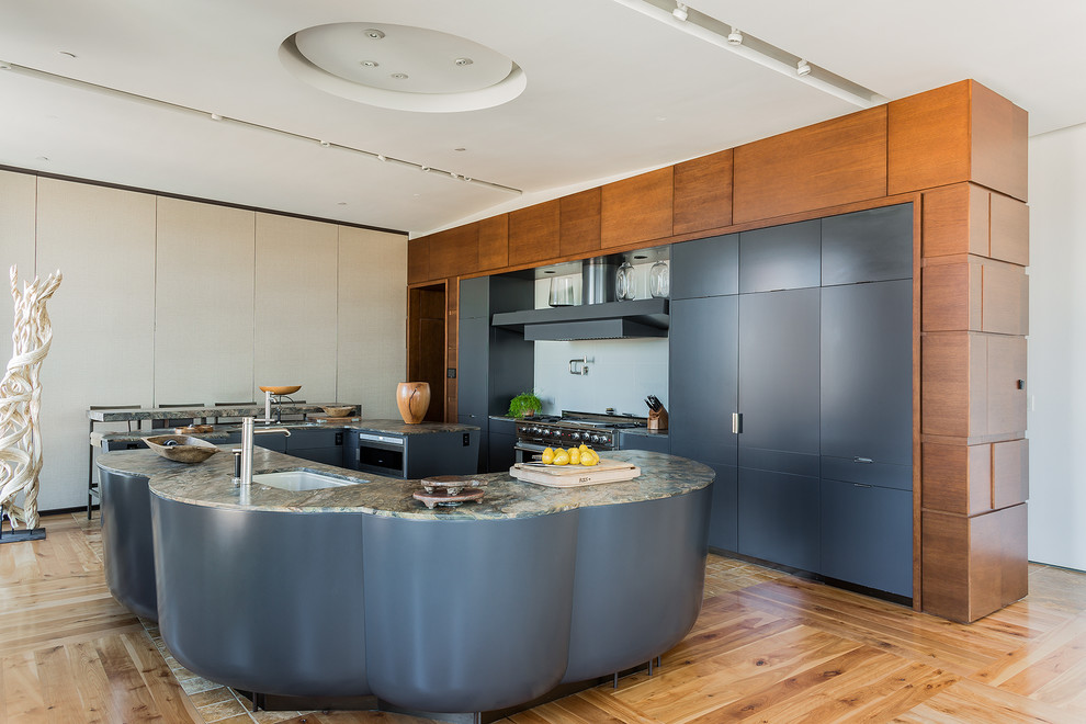Moderne Küche mit Unterbauwaschbecken, flächenbündigen Schrankfronten, grauen Schränken, hellem Holzboden, zwei Kücheninseln und Elektrogeräten mit Frontblende in Boston