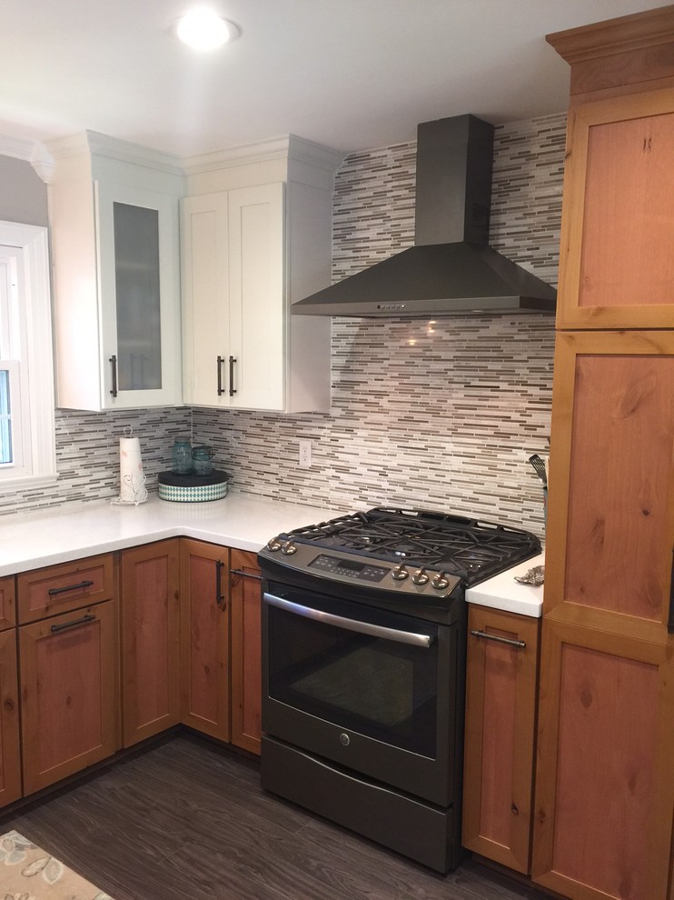 Example of a mid-sized classic dark wood floor enclosed kitchen design in Nashville with a double-bowl sink, shaker cabinets, medium tone wood cabinets, quartzite countertops, multicolored backsplash, matchstick tile backsplash, black appliances and a peninsula