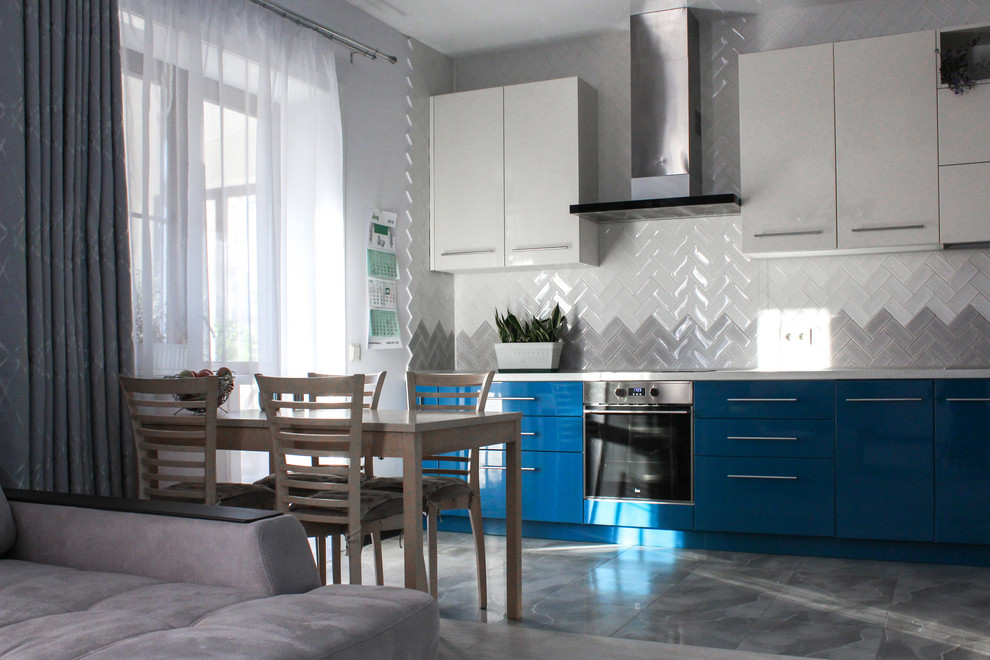 Exempel på ett litet modernt vit vitt kök, med en enkel diskho, släta luckor, blå skåp, bänkskiva i kvarts, vitt stänkskydd, stänkskydd i keramik, vita vitvaror, klinkergolv i keramik och grått golv