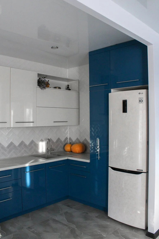 Idéer för små funkis vitt kök, med en enkel diskho, släta luckor, blå skåp, bänkskiva i kvarts, vitt stänkskydd, stänkskydd i keramik, vita vitvaror, klinkergolv i keramik och grått golv