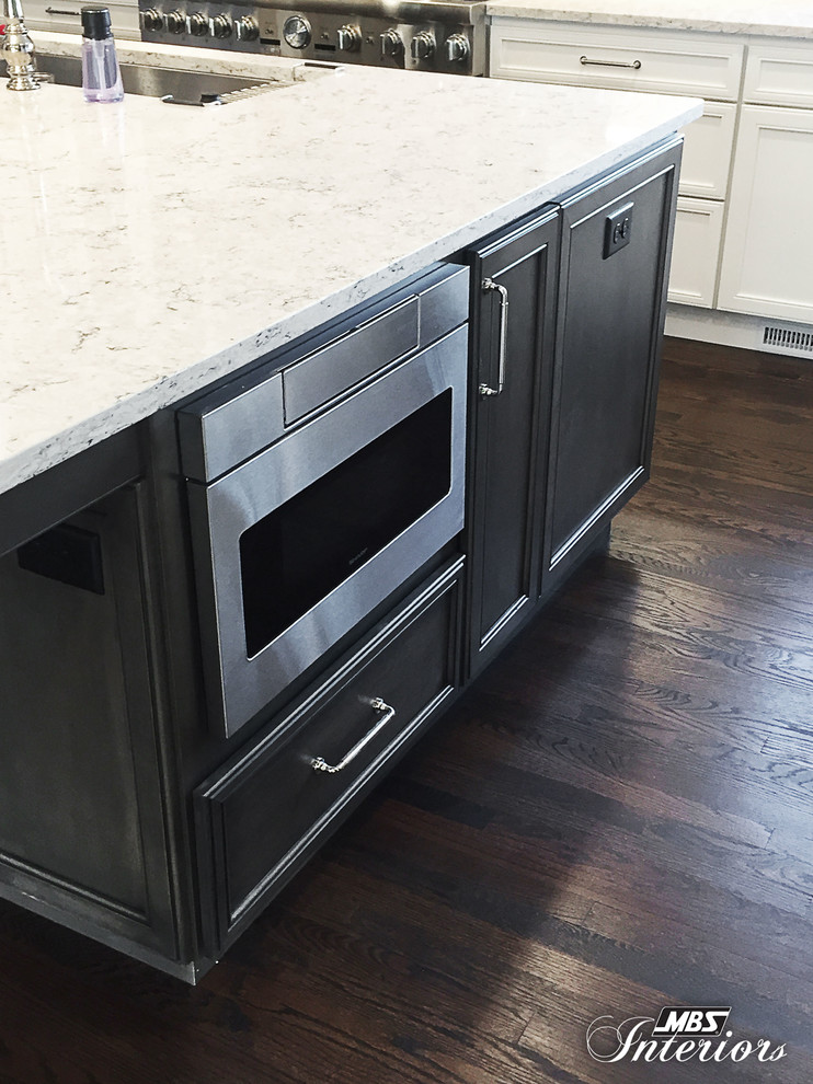 Inspiration for a huge transitional l-shaped dark wood floor and brown floor eat-in kitchen remodel in Cincinnati with an undermount sink, recessed-panel cabinets, white cabinets, quartz countertops, beige backsplash, glass tile backsplash, stainless steel appliances and an island