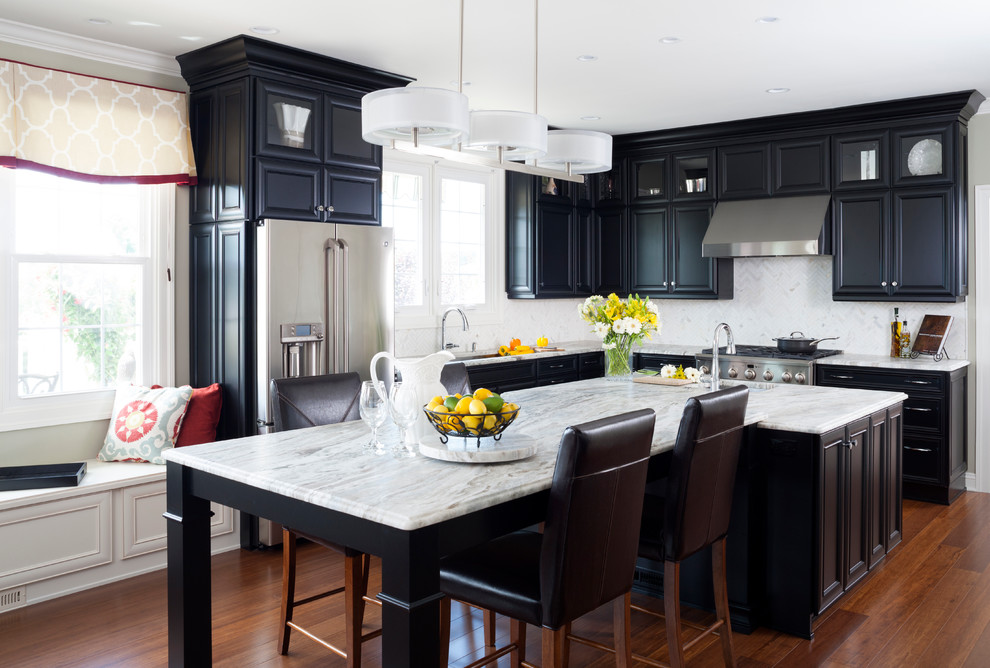 Example of a mid-sized classic l-shaped medium tone wood floor and beige floor eat-in kitchen design in DC Metro with recessed-panel cabinets, black cabinets, white backsplash, stainless steel appliances, an island, an undermount sink, marble countertops and stone tile backsplash
