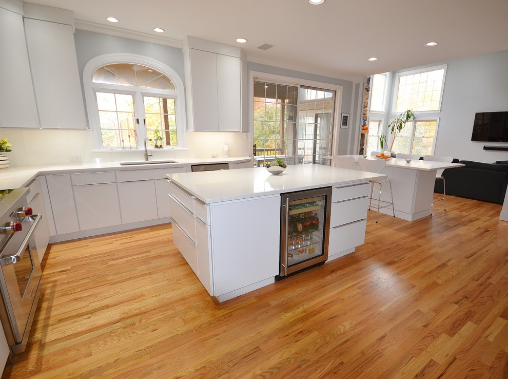 Eat-in kitchen - large scandinavian l-shaped medium tone wood floor and brown floor eat-in kitchen idea in Philadelphia with an undermount sink, flat-panel cabinets, white cabinets, quartz countertops, white backsplash, ceramic backsplash, stainless steel appliances and an island