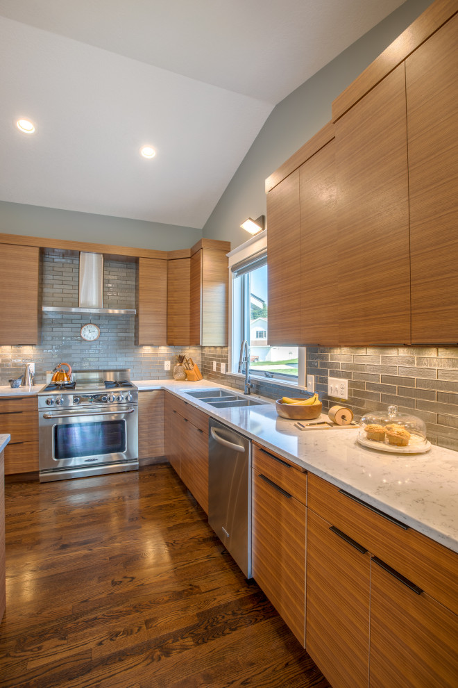 Mid-sized mid-century modern u-shaped medium tone wood floor and beige floor eat-in kitchen photo in Other with an undermount sink, flat-panel cabinets, medium tone wood cabinets, quartz countertops, gray backsplash, subway tile backsplash, stainless steel appliances, an island and white countertops