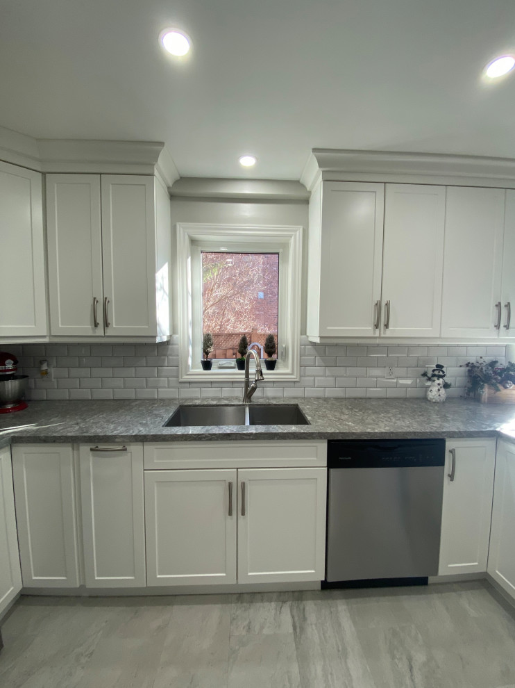Exempel på ett klassiskt grå grått kök, med en undermonterad diskho, skåp i shakerstil, vita skåp, bänkskiva i kvarts, grått stänkskydd, stänkskydd i keramik, rostfria vitvaror, klinkergolv i keramik, en halv köksö och grått golv
