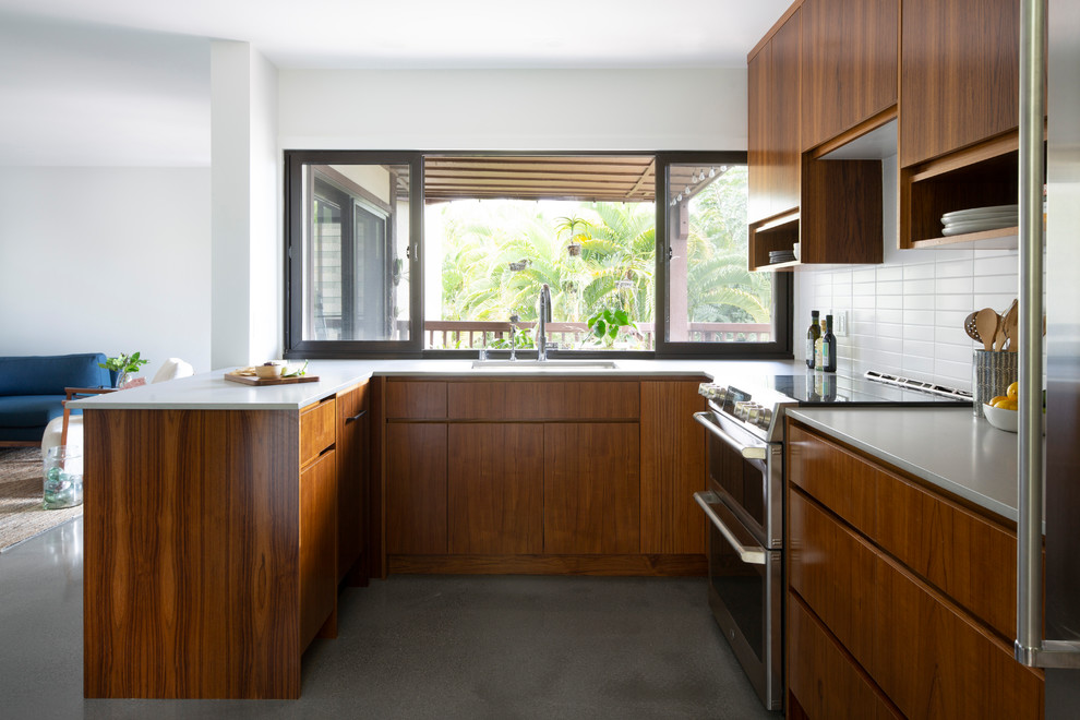 Idéer för att renovera ett mellanstort retro grå grått kök, med en undermonterad diskho, släta luckor, skåp i mellenmörkt trä, bänkskiva i kvarts, vitt stänkskydd, stänkskydd i cementkakel, rostfria vitvaror, betonggolv, en halv köksö och grått golv