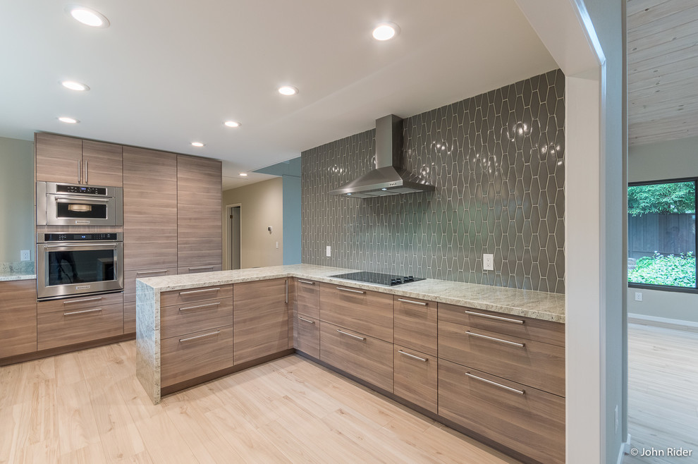 Photo of a medium sized contemporary l-shaped enclosed kitchen in San Francisco with a submerged sink, flat-panel cabinets, grey cabinets, granite worktops, grey splashback, ceramic splashback, stainless steel appliances, porcelain flooring, a breakfast bar and beige floors.
