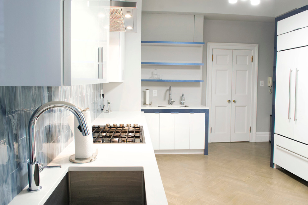 Mittelgroße Moderne Küche mit flächenbündigen Schrankfronten, weißen Schränken, Küchenrückwand in Blau, Rückwand aus Porzellanfliesen und Küchengeräten aus Edelstahl in New York