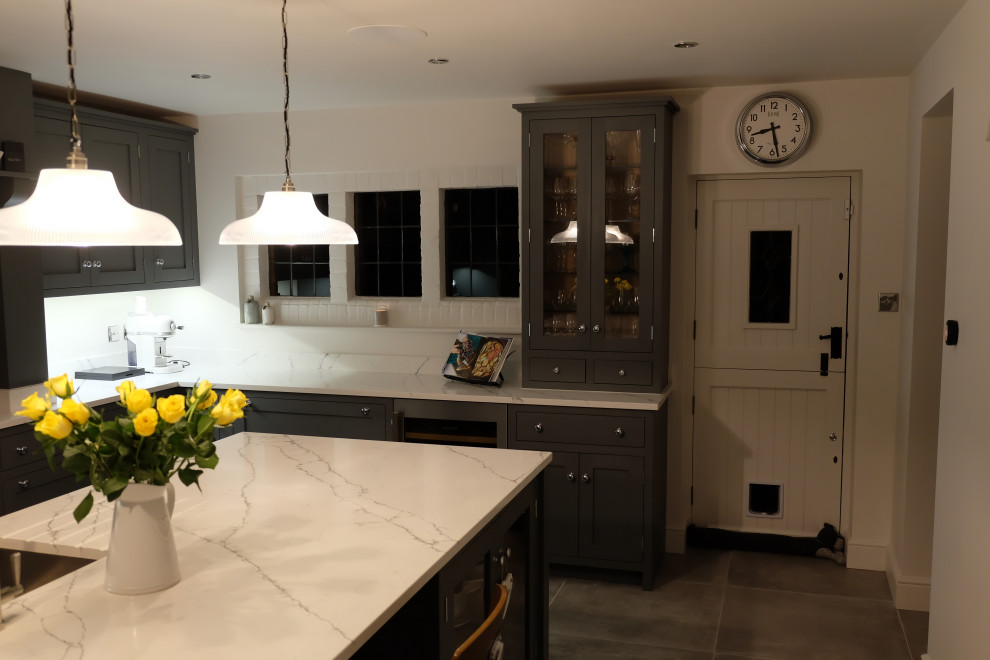 Design ideas for a large contemporary u-shaped open plan kitchen in Surrey with a built-in sink, beaded cabinets, grey cabinets, quartz worktops, an island and white worktops.