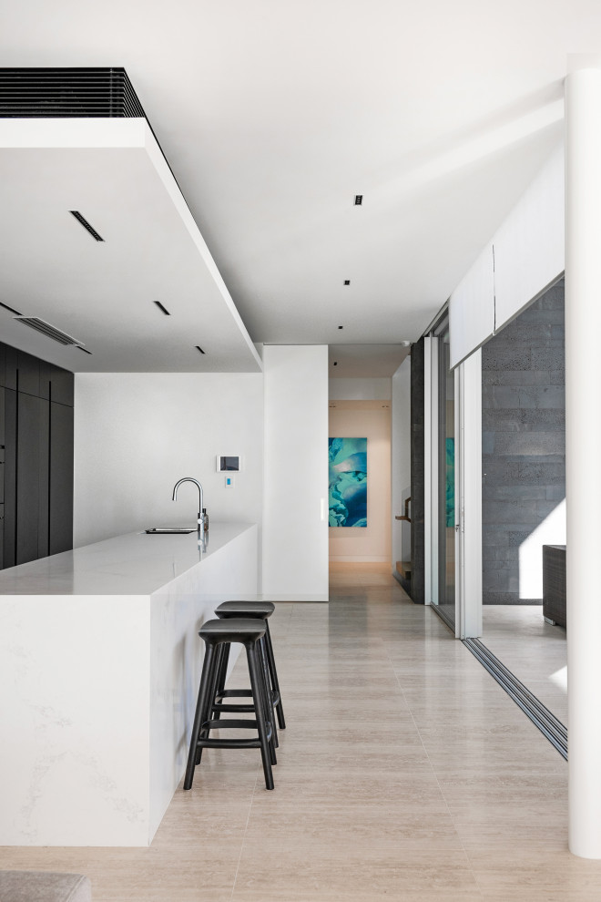 Example of a mid-sized trendy single-wall light wood floor and brown floor open concept kitchen design in Perth with a single-bowl sink, flat-panel cabinets, black cabinets, quartz countertops, black backsplash, stainless steel appliances, an island and white countertops