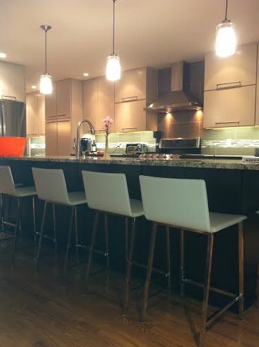 Zweizeilige, Mittelgroße Moderne Wohnküche mit Landhausspüle, flächenbündigen Schrankfronten, grauen Schränken, Granit-Arbeitsplatte, Küchenrückwand in Beige, Rückwand aus Glasfliesen, Küchengeräten aus Edelstahl, dunklem Holzboden und Kücheninsel in Denver