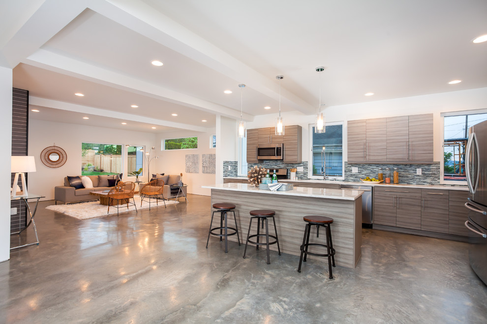 Photo of a large modern l-shaped open plan kitchen in Seattle with a submerged sink, flat-panel cabinets, grey cabinets, engineered stone countertops, blue splashback, mosaic tiled splashback, stainless steel appliances, concrete flooring and an island.