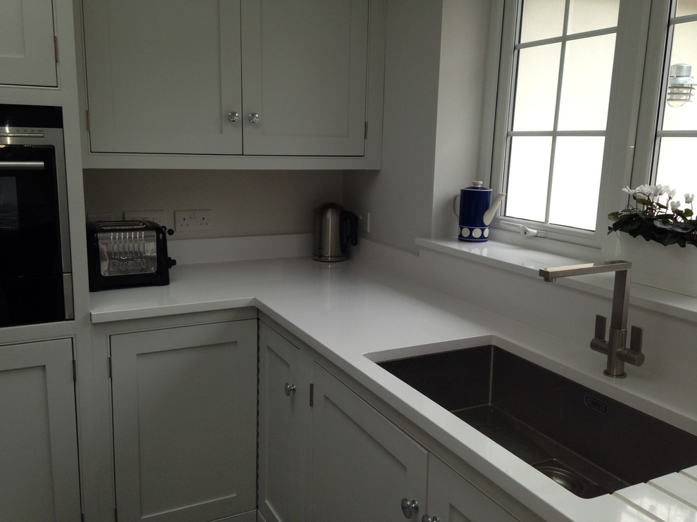 Exempel på ett stort modernt vit vitt l-kök, med luckor med profilerade fronter, grå skåp, en köksö och grått golv