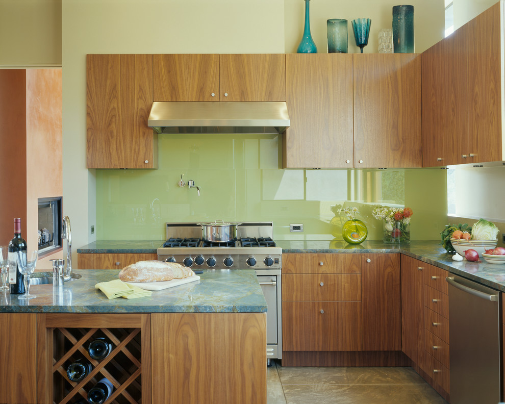 Источник вдохновения для домашнего уюта: угловая кухня в современном стиле с плоскими фасадами, фасадами цвета дерева среднего тона, зеленым фартуком, фартуком из стекла, островом и зеленой столешницей