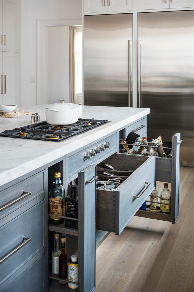 Inspiration for a transitional light wood floor kitchen remodel in New York with blue cabinets, stainless steel appliances and an island