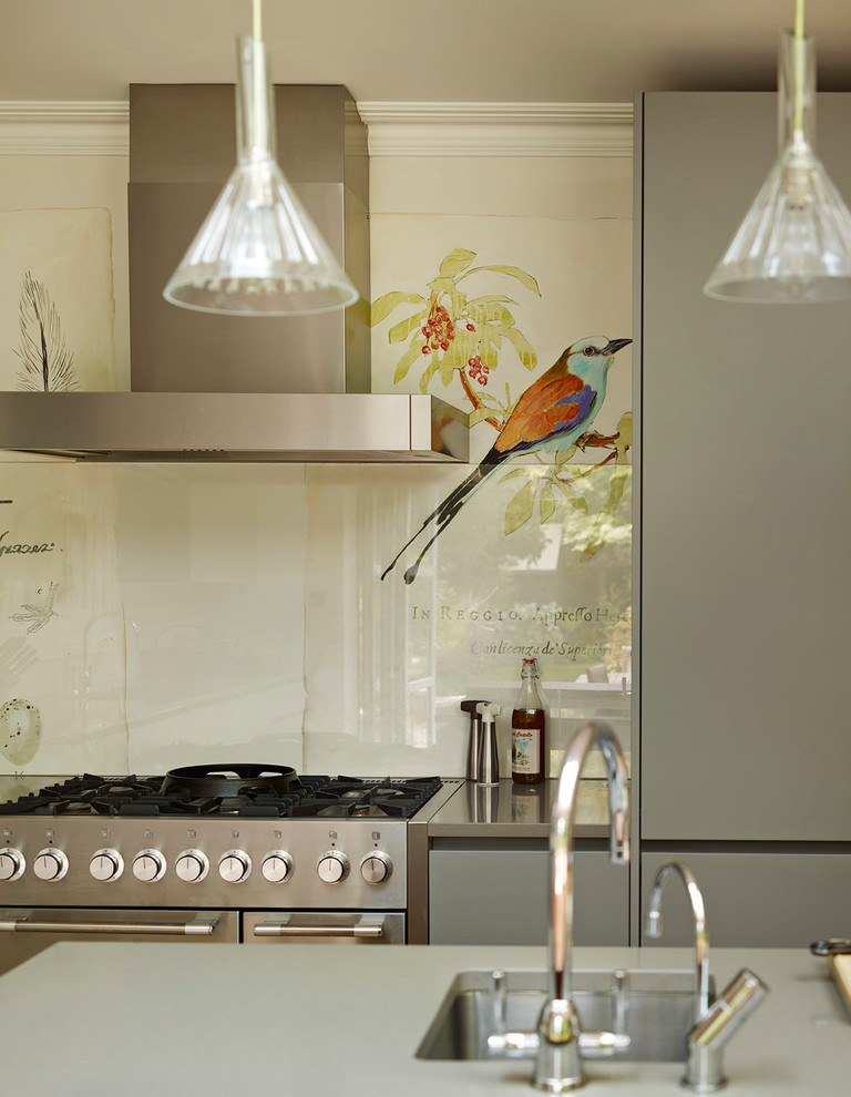 Bild på ett stort funkis grå grått kök, med en integrerad diskho, grå skåp, bänkskiva i kvartsit, beige stänkskydd, glaspanel som stänkskydd, rostfria vitvaror, ljust trägolv, en köksö och beiget golv