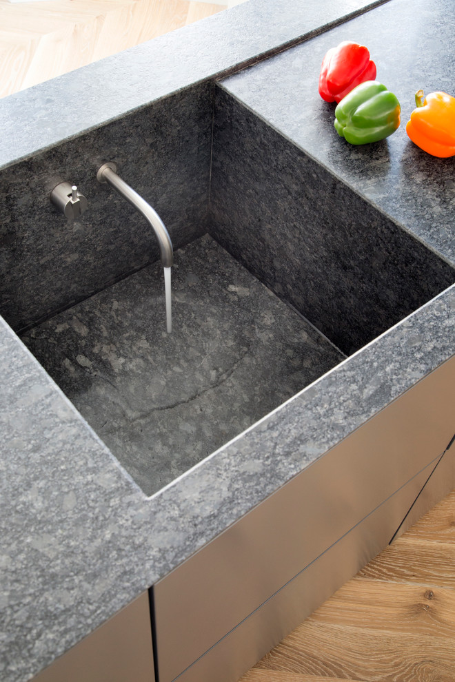 Foto di una cucina contemporanea di medie dimensioni con lavello integrato, ante lisce, top in granito, ante nere, elettrodomestici in acciaio inossidabile, pavimento beige e top nero