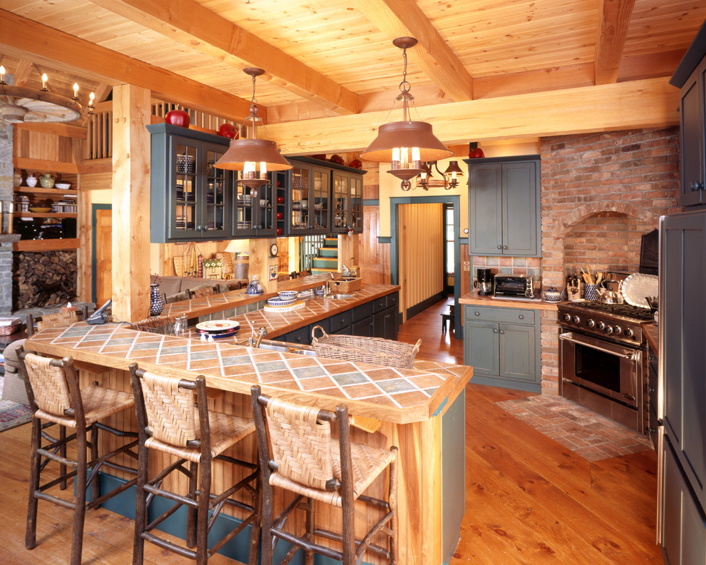 Rustic kitchen in Burlington with glass-front cabinets and tile countertops.