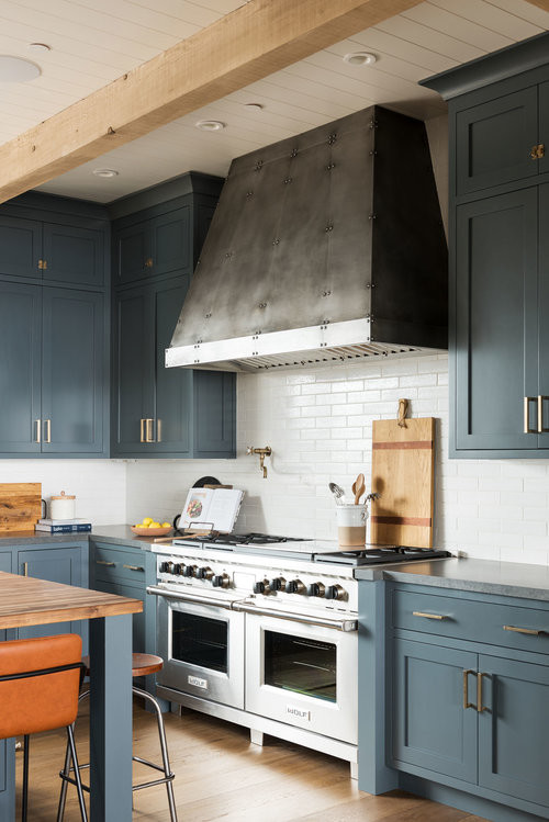 Inspiration för ett stort vintage kök, med blå skåp, vitt stänkskydd, stänkskydd i tunnelbanekakel, rostfria vitvaror, mellanmörkt trägolv, en köksö och brunt golv