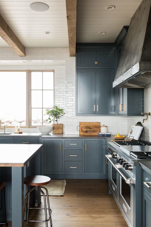 Foto di una grande cucina classica con ante blu, paraspruzzi bianco, paraspruzzi con piastrelle diamantate, elettrodomestici in acciaio inossidabile, pavimento in legno massello medio e pavimento marrone