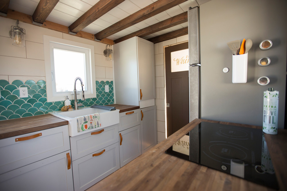 Small scandi galley open plan kitchen in Los Angeles with a belfast sink, flat-panel cabinets, grey cabinets, wood worktops, terracotta splashback, stainless steel appliances, bamboo flooring, no island, brown floors and brown worktops.