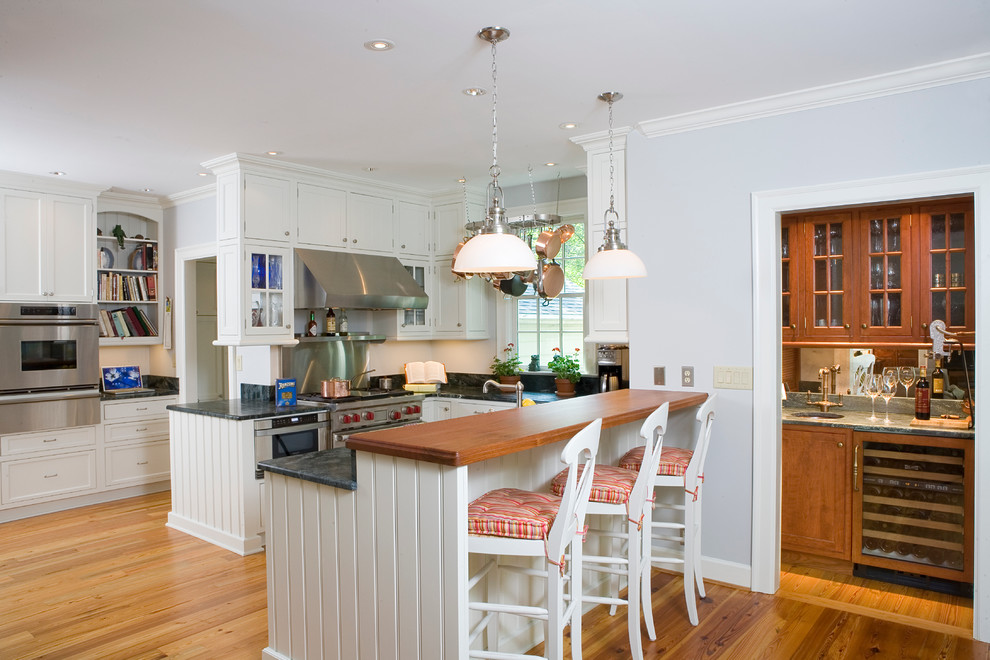 Klassische Küchenbar mit Schrankfronten im Shaker-Stil, weißen Schränken, Küchenrückwand in Schwarz und Küchengeräten aus Edelstahl in Atlanta