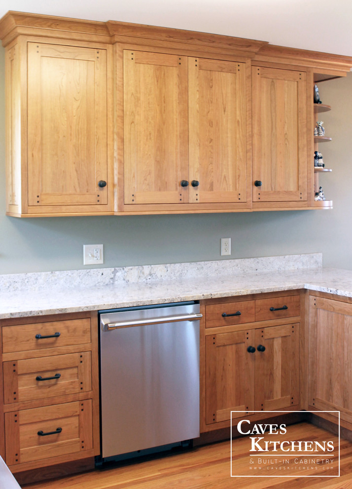 Bild på ett litet amerikanskt kök, med luckor med infälld panel, skåp i mellenmörkt trä, granitbänkskiva, rostfria vitvaror, en undermonterad diskho, flerfärgad stänkskydd, stänkskydd i sten, mellanmörkt trägolv och en halv köksö
